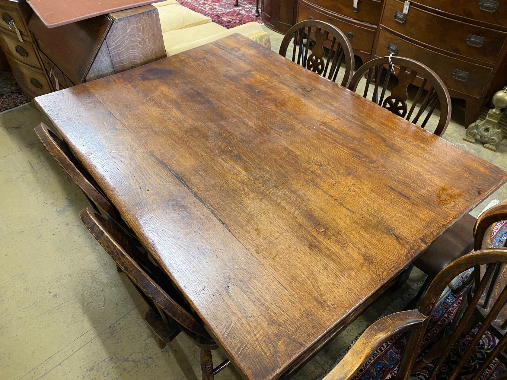 A small 18th century style rectangular oak refectory dining table, length 137cm, width 98cm, height 75cm and a harlequin set of six elm and beech Windsor wheelback dining chairs, two with arms